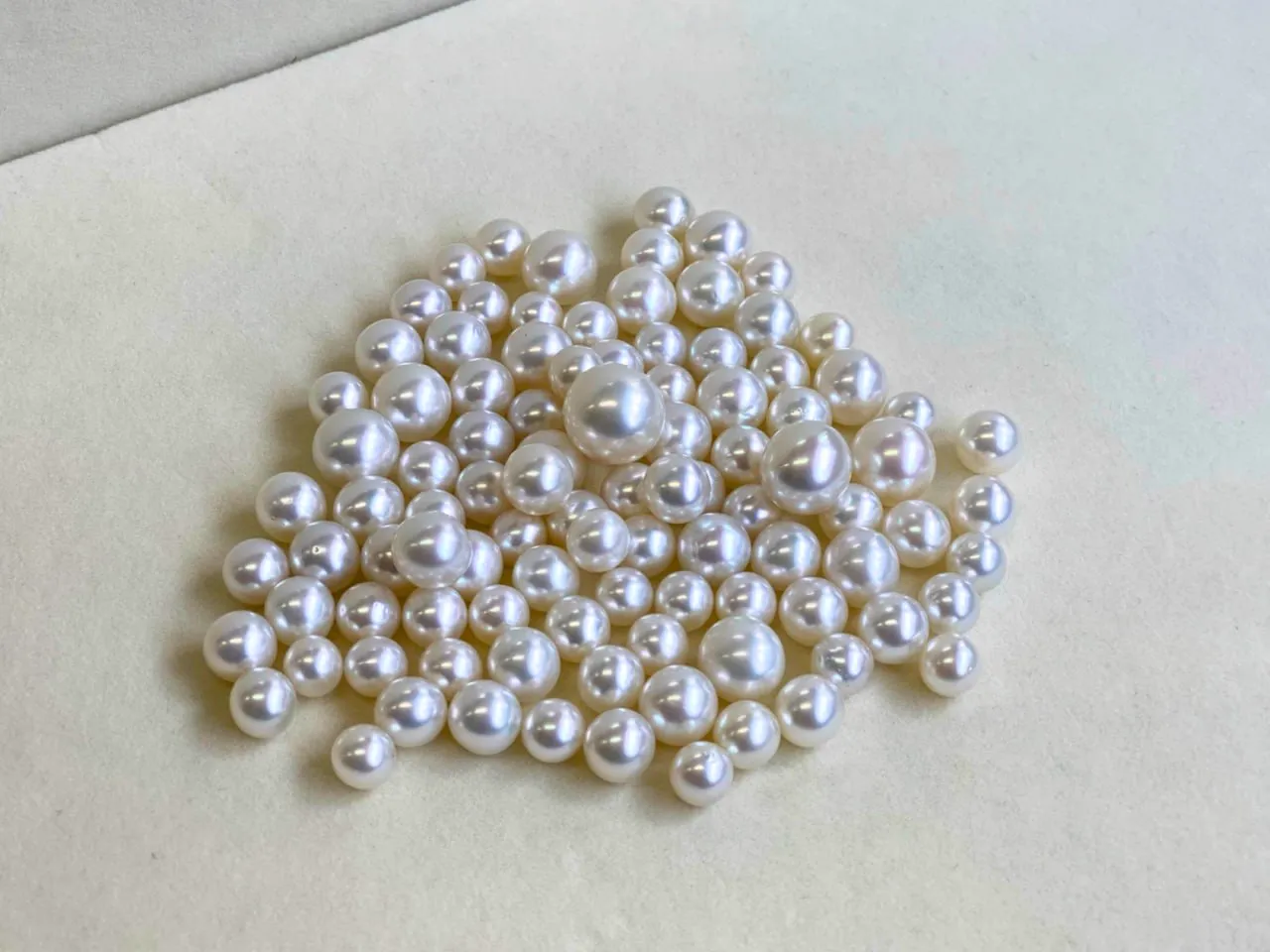 Loose white South Sea pearls on cream suede